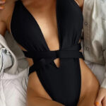 Femme portant un maillot de bain noir une pièce.