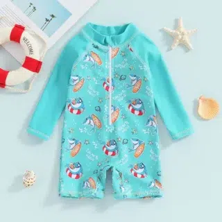 Sur fond blanc on voit un maillot de bain bleu une pièce pour bébé manches longues et jambes 3/4 à l'imprimé requin.