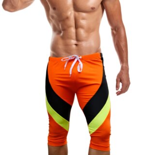 On voit un homme qui porte un long maillot de bain en dessous du genou. Il est orange et noir.