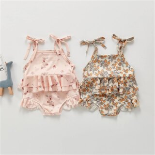 Photo de deux maillots de bains deux pièces à froufrous pour bébé filles l'un rose l'autre beige