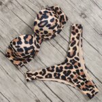 Photo d'un maillot de bain léopard deux pièces, bustier push-u et tanga, posé sur du parquet