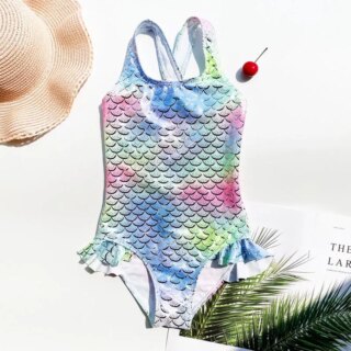 Maillot de bain avec des écailles multicolores, un chapeau en paille et des feuilles de palmiers