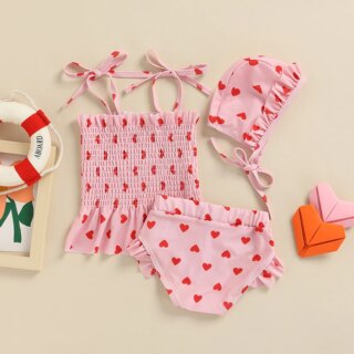 Photo montrant un maillot de bain pour bébé filles trois pièces imprimé coeurs rouge sur rose