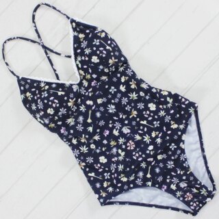 Maillot de bain une pièce bleu sur fond blanc.