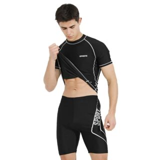 Sur fond blanc, on voit un homme brun qui porte un maillot de bain deux pièces pour homme composé d'un T-shirt noir et d'un short assorti lui arrivant mi-cuisse.