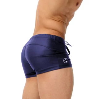 On voit les fesses d'un homme qui porte un maillot de bain type boxer, bleu, très ajusté.