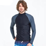 Homme portant un maillot de bain à manches longues noir et gris sur un fond blanc.