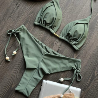 Maillot de bain vert sur un fond gris foncé.