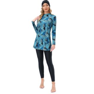 On voit une femme qui porte un maillot de bain burkini bleu. Elle a la tête couverte et se touche l'épaule droite.