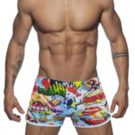 On voit un homme qui porte un boxer de bain coloré avec des motifs cartoon.