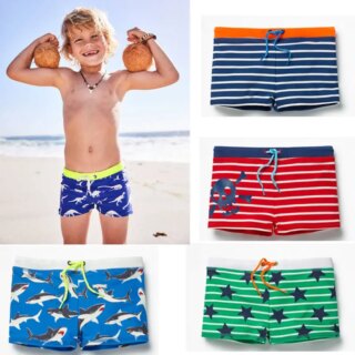 Enfant portant un short de bain bleu et se trouvant sur la plage. On voit également les différents coloris sur un fond blanc.