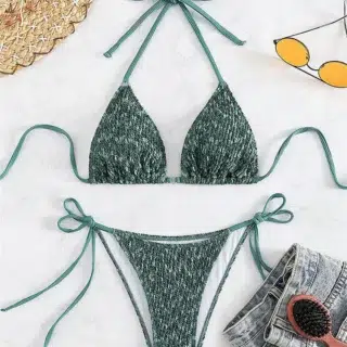Image montrant un maillot de bain vert ficelle dos nu noué un chapeau des lunettes de soleil jaune et une brosse